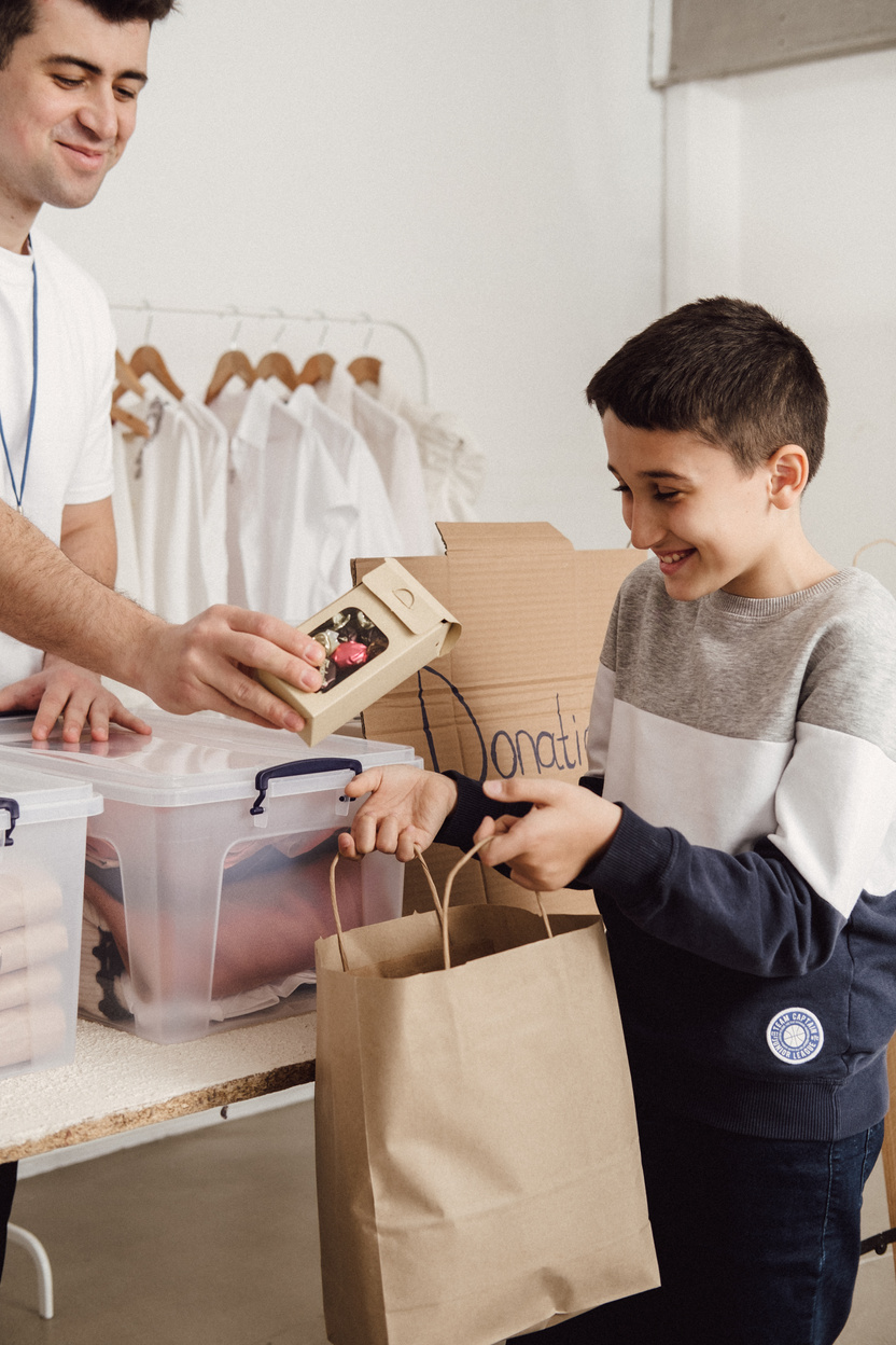 Boy Receiving Donations from Volunteer